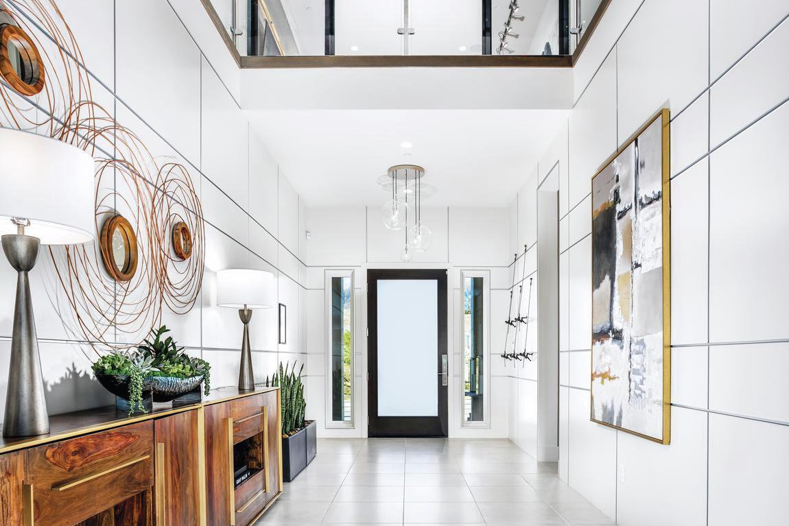 Contemporary home entrance featuring sleek material, clean lines, and eye-catching furniture and art