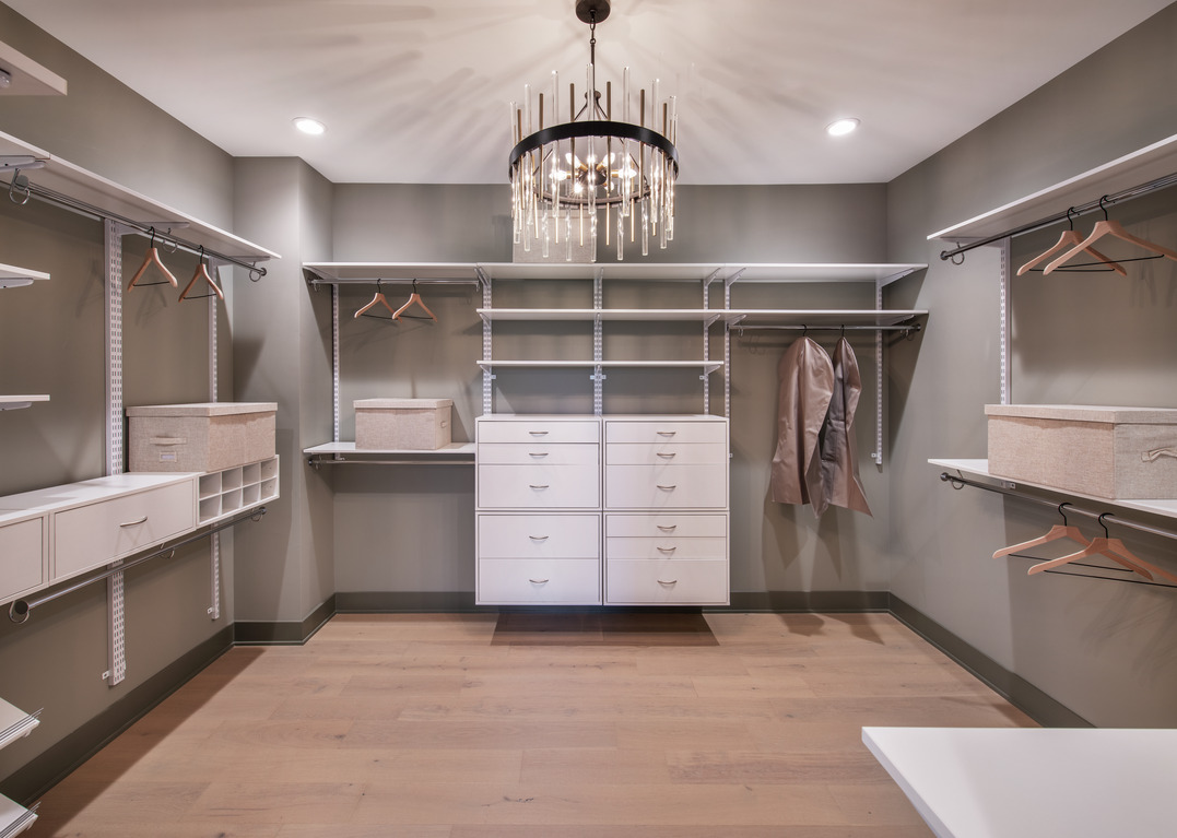 Flex room converted into walk-in closet with ample hanging racks and drawers