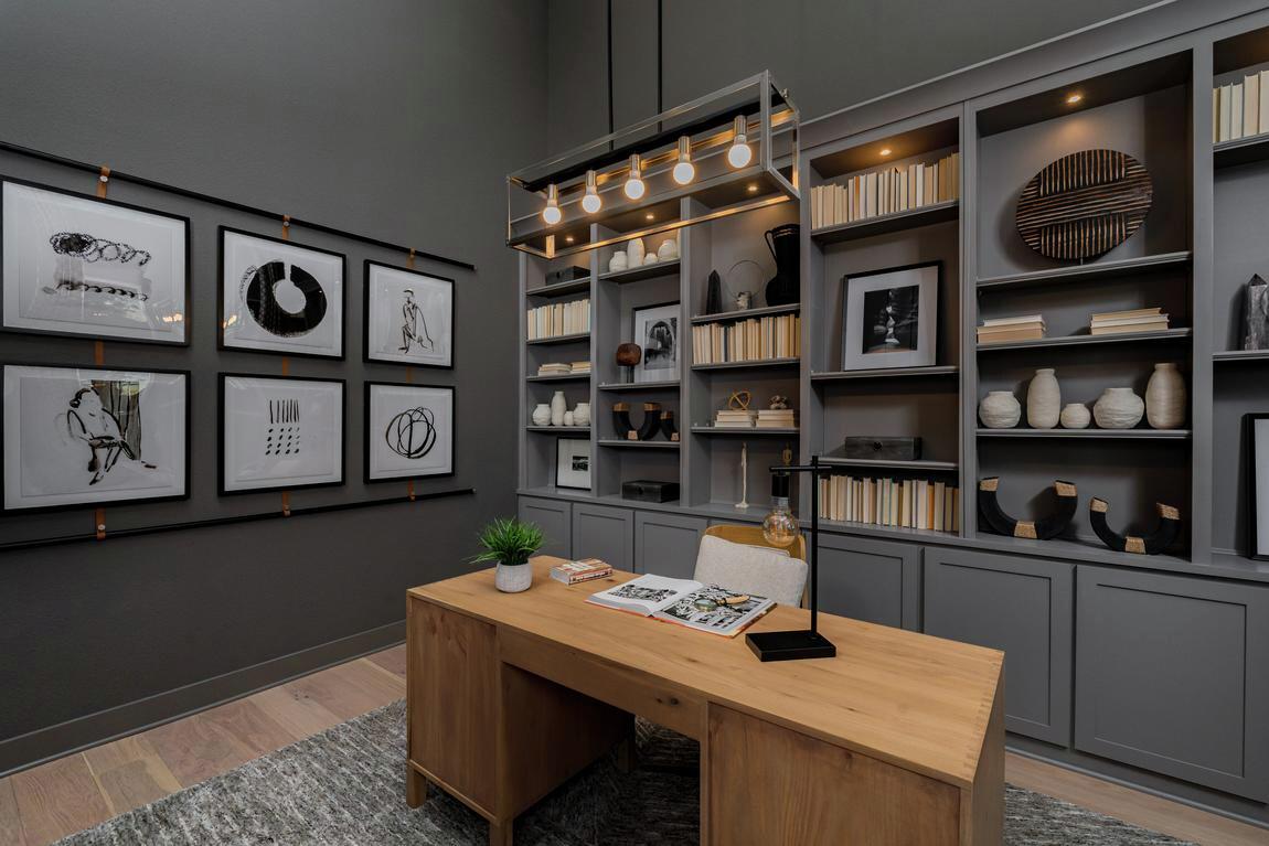 Dark-toned home office with built-in shelving and pendant lighting