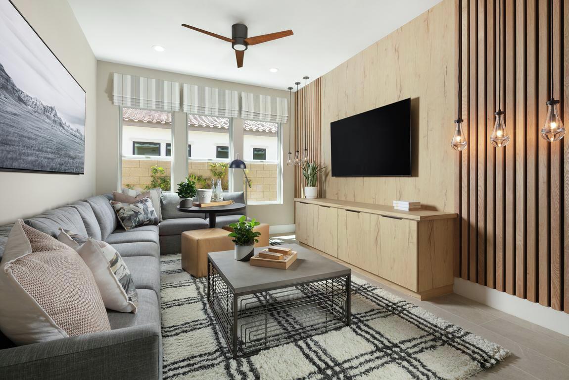 Entertainment room elevated by wood accent wall and industrial pendant lighting