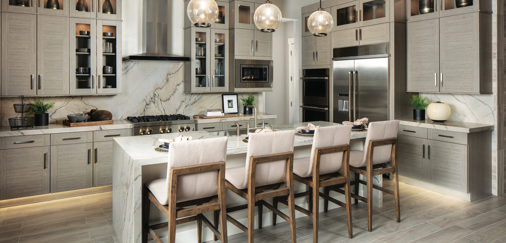Kitchen with quartz waterfall island, pendant lighting, and neutral wood furniture