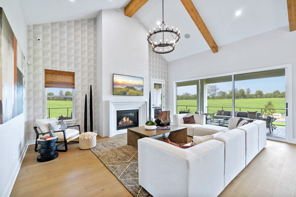 spacious great room featuring accent fireplace wall and wallpaper design