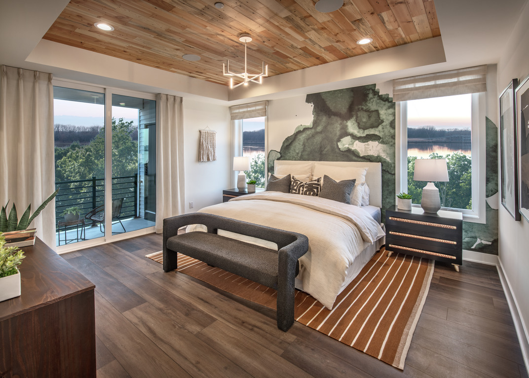 Primary bedroom highlighted by accent wall and watercolor wallpaper design