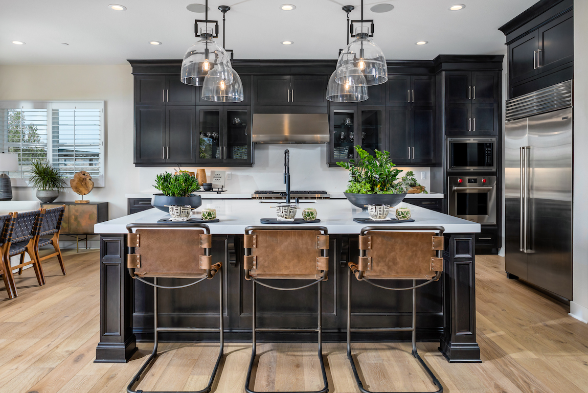 Regency at Folsom Ranch kitchen with leather chairs and black cabinets. 