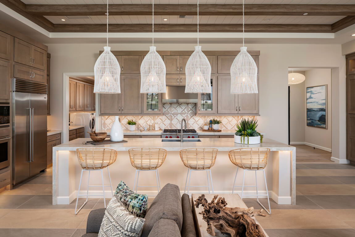 Modern kitchen featuring southwestern interior design elements like patterned backsplash, stone countertops, and wicker furniture