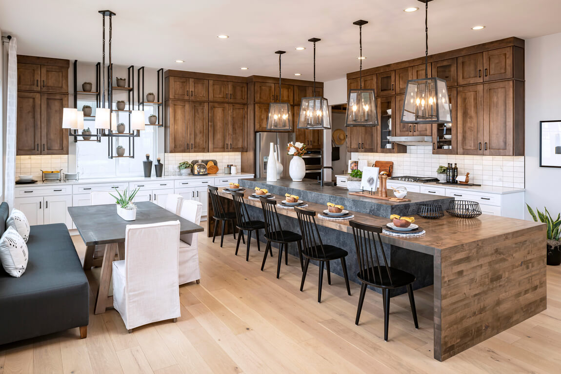 Modern kitchen featuring oversized waterall island highlighted by mix of wood and natural stone