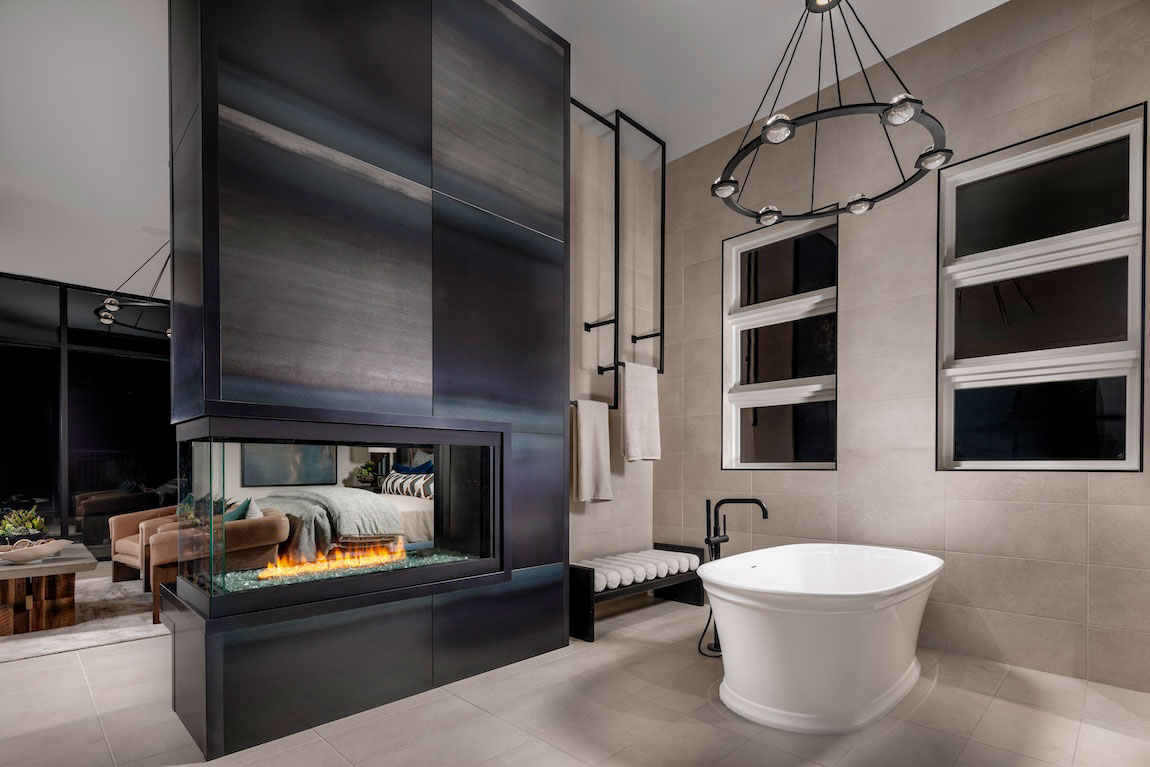 Primary bathroom en-suite with double-sided transparent gas and electric fireplace