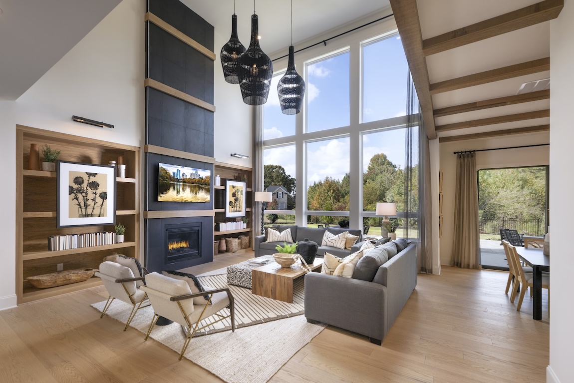 Two-story great room with fireplace and tv above mantel with artwork and decor