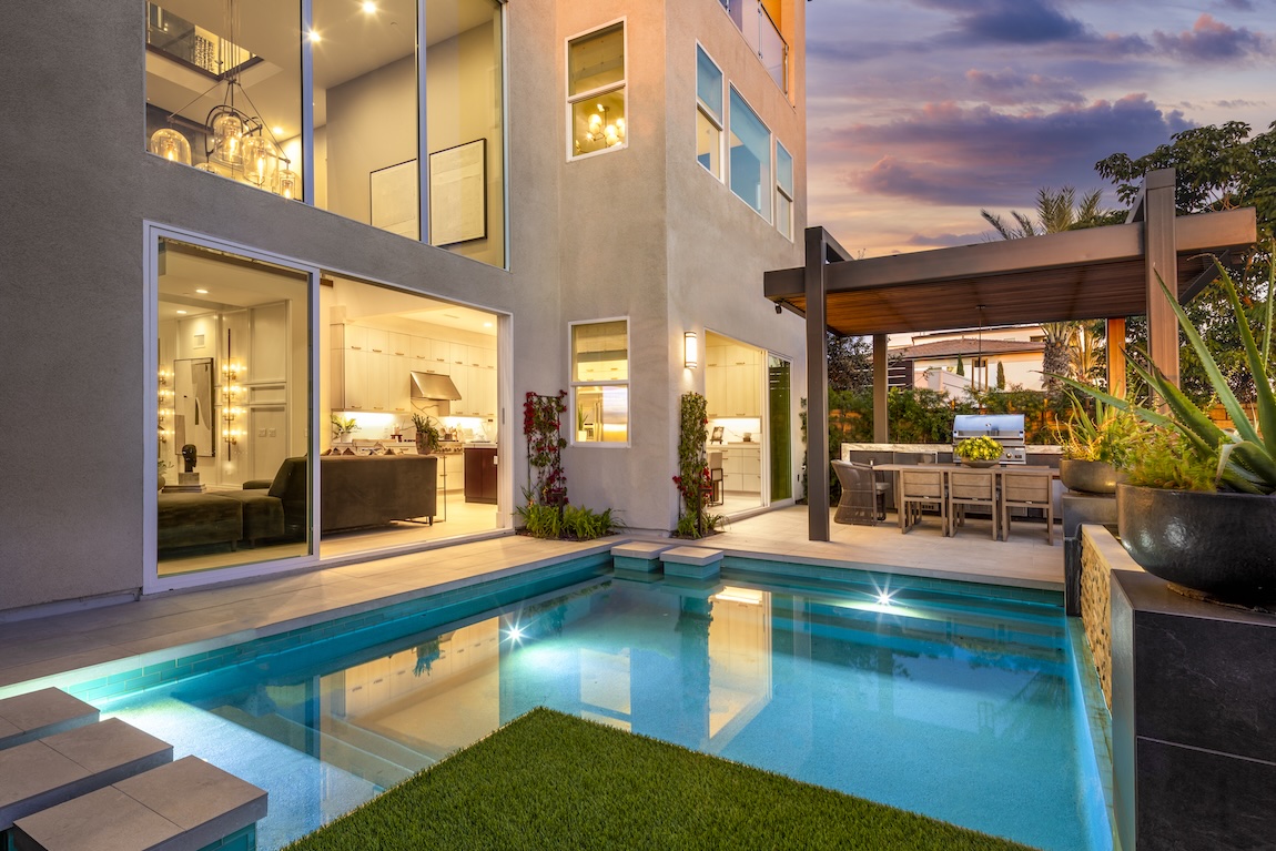 luxury outdoor living space featuring pool, kitchen, and hardscape lighting