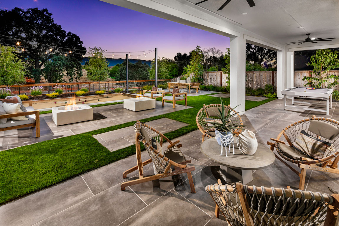 Exterior photo of backyard with fire pit, pool table and outdoor seating area. 