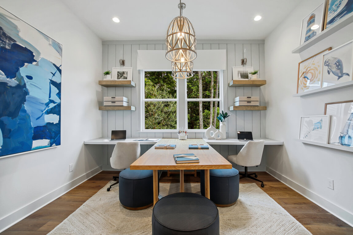 Two person office layout idea featuring blue art and modern seating