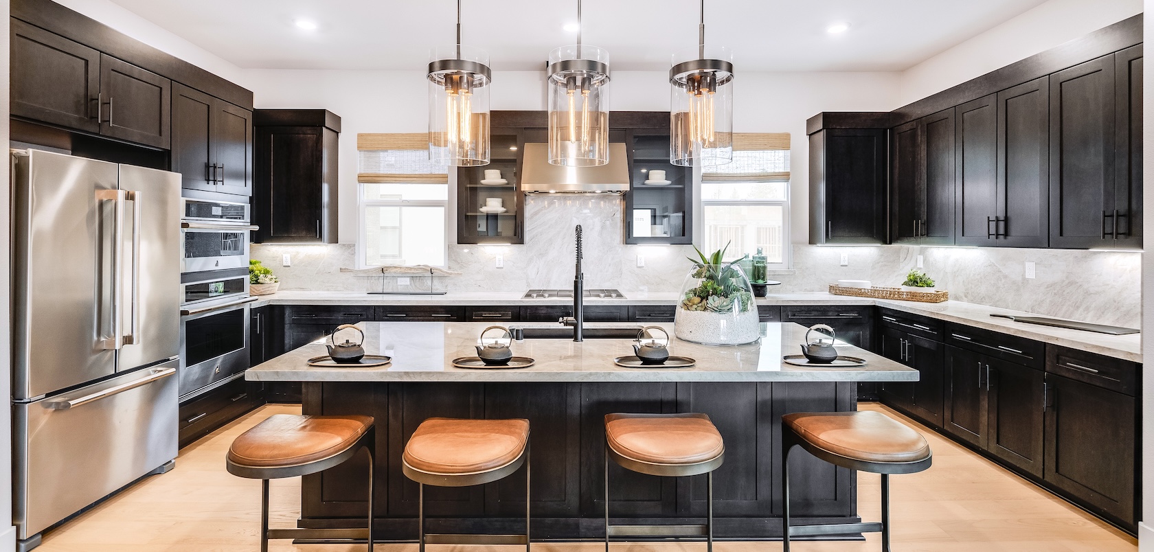Luxury kitchen with quartz island and pendant lighting fixtures.