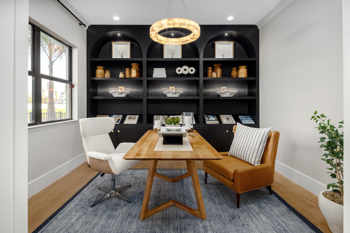 home office with built in shelves and statement lighting