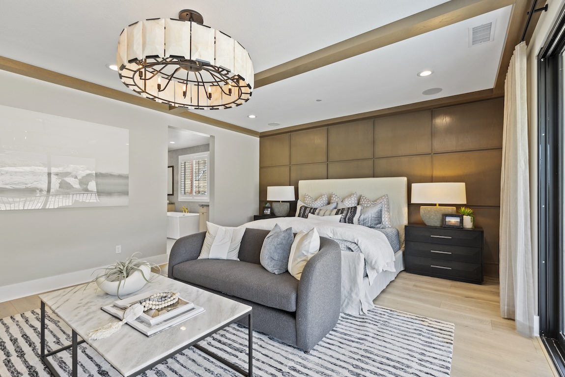 contemporary bedroom design featuring geometric accent wall and grand chandelier