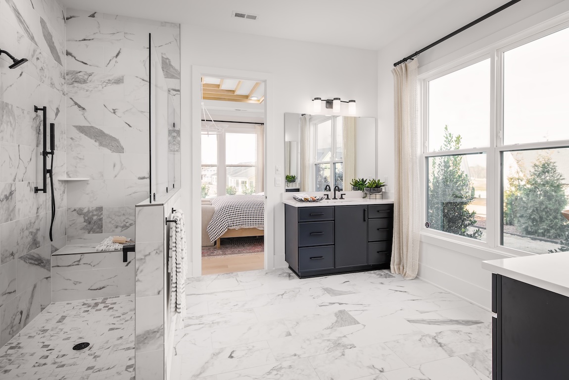 primary bathroom with marble tile and natural light