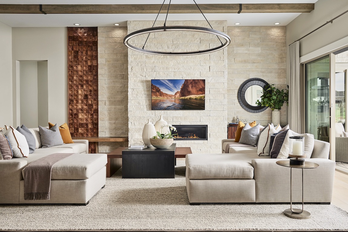 Stunning modern great room with innovative fireplace, stone accent wall, and transition to outdoor living spaces through sliding glass doors.