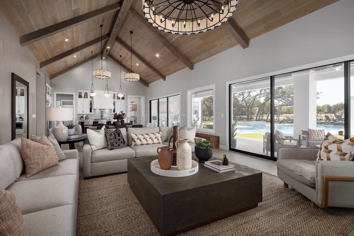 modern great room with wooden ceiling and statement chandelier above